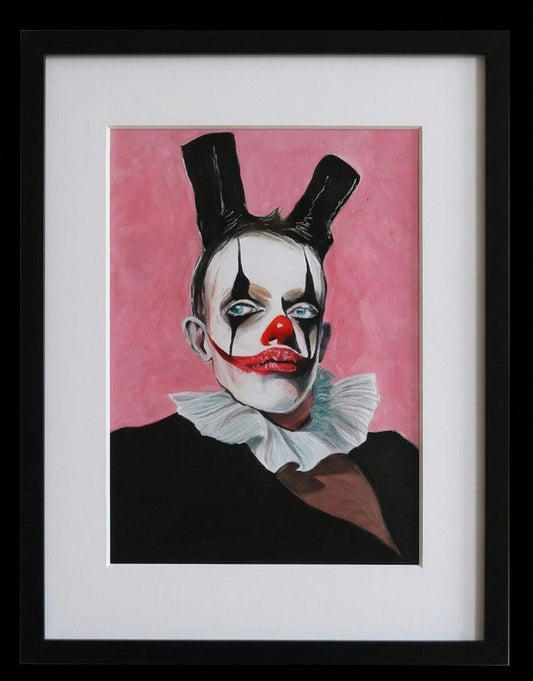 Framed artwork of a clown with a pink background on a white wall